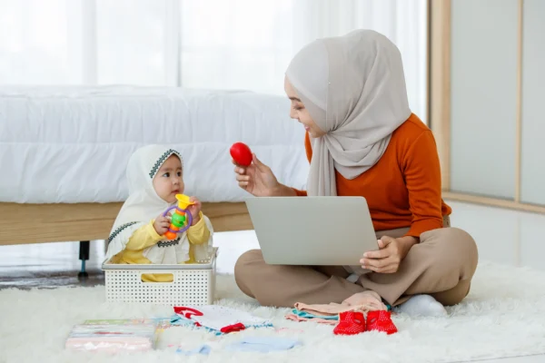 A woman and baby playing with toys on the floor