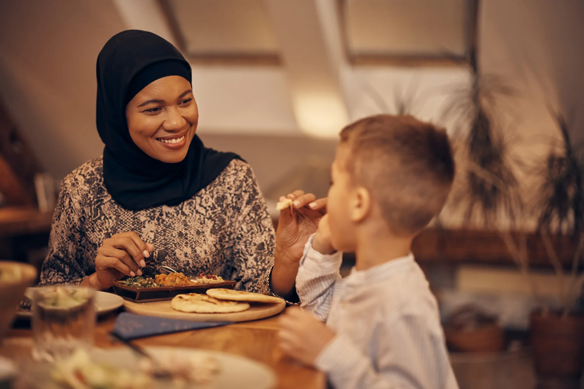 A woman and boy sitting at the table eating.