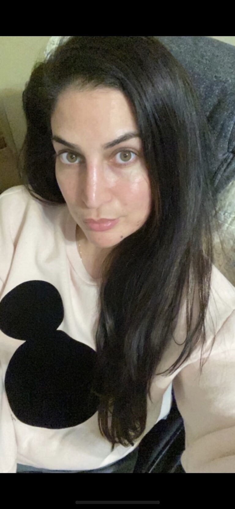 A woman with long black hair and a mickey mouse shirt.