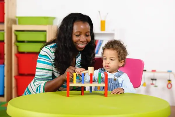 A woman and child playing with wooden toys.