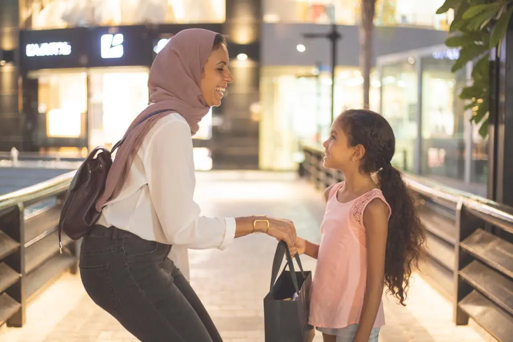 A woman and girl are talking in the mall.