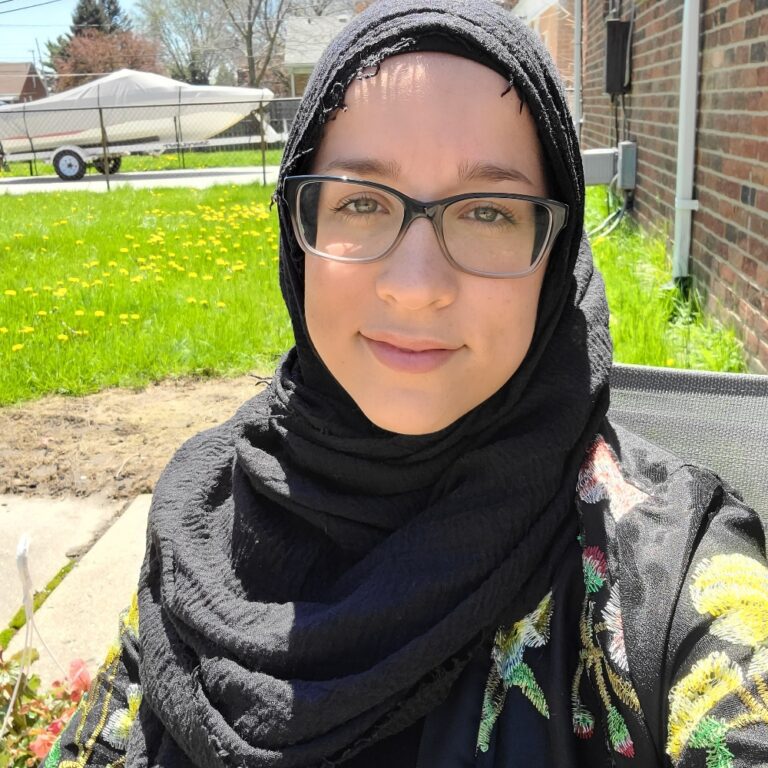 A woman wearing glasses and a hijab