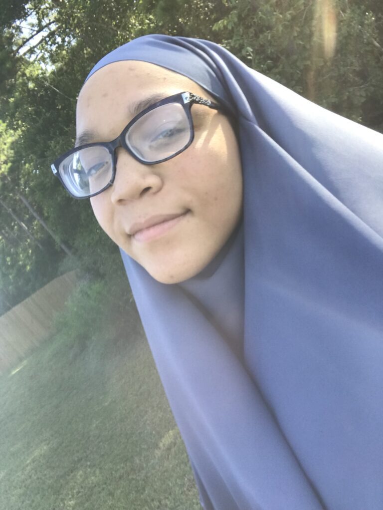 A woman wearing glasses and a hijab