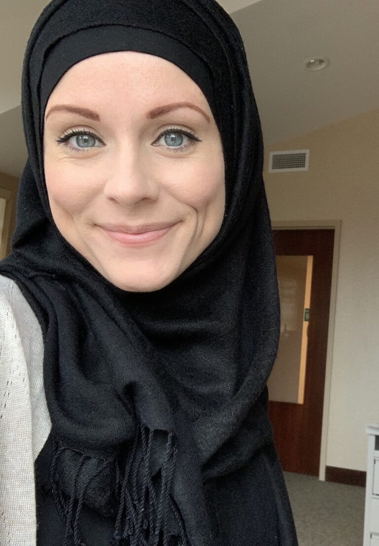 A woman with blue eyes wearing a black hijab.