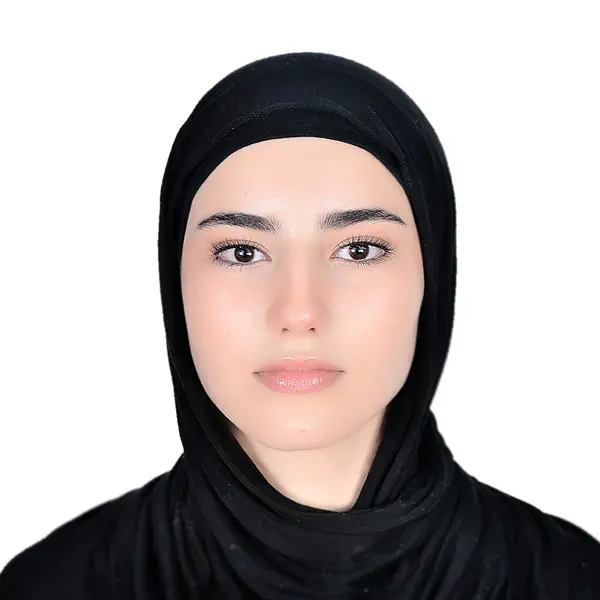 A woman wearing black and standing with a white background