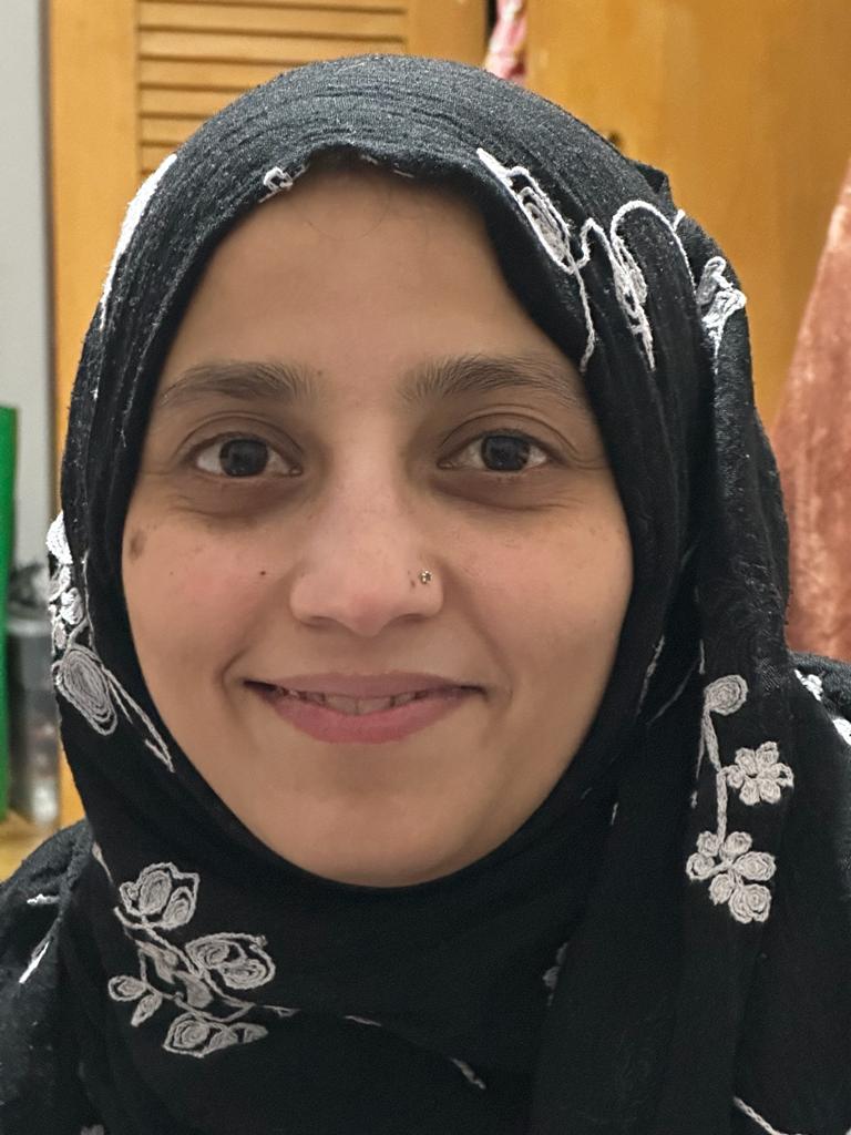 A closeup look of a woman wearing black and smiling.