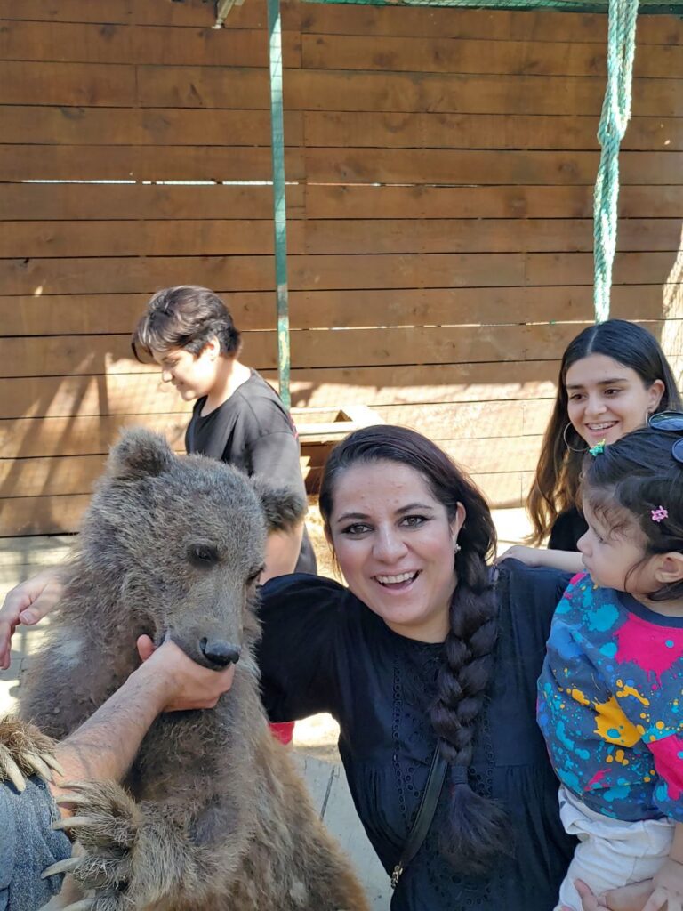 A woman and her children playing with a pet bear