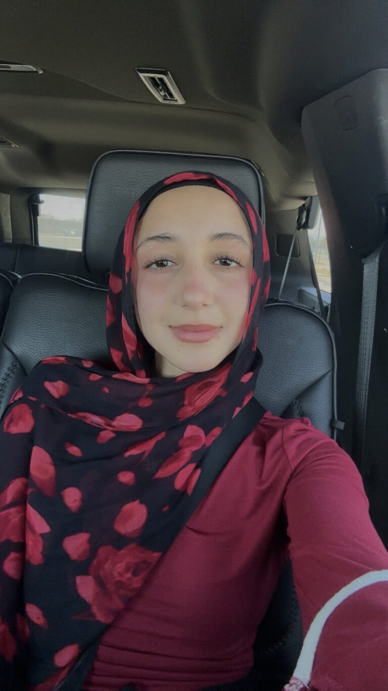 A Woman In A Red COlor Top And A Scarf