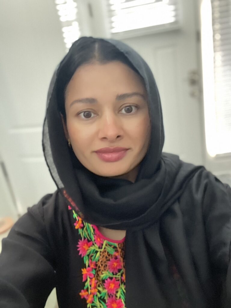 Woman wearing black hijab with colorful embroidery.