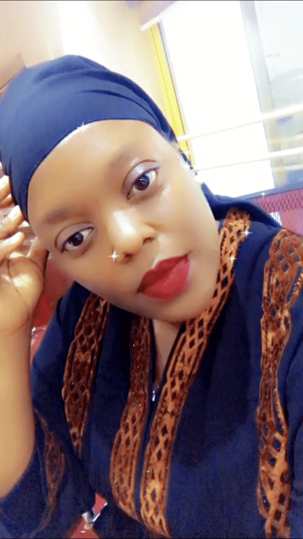 Woman in headscarf with patterned attire.
