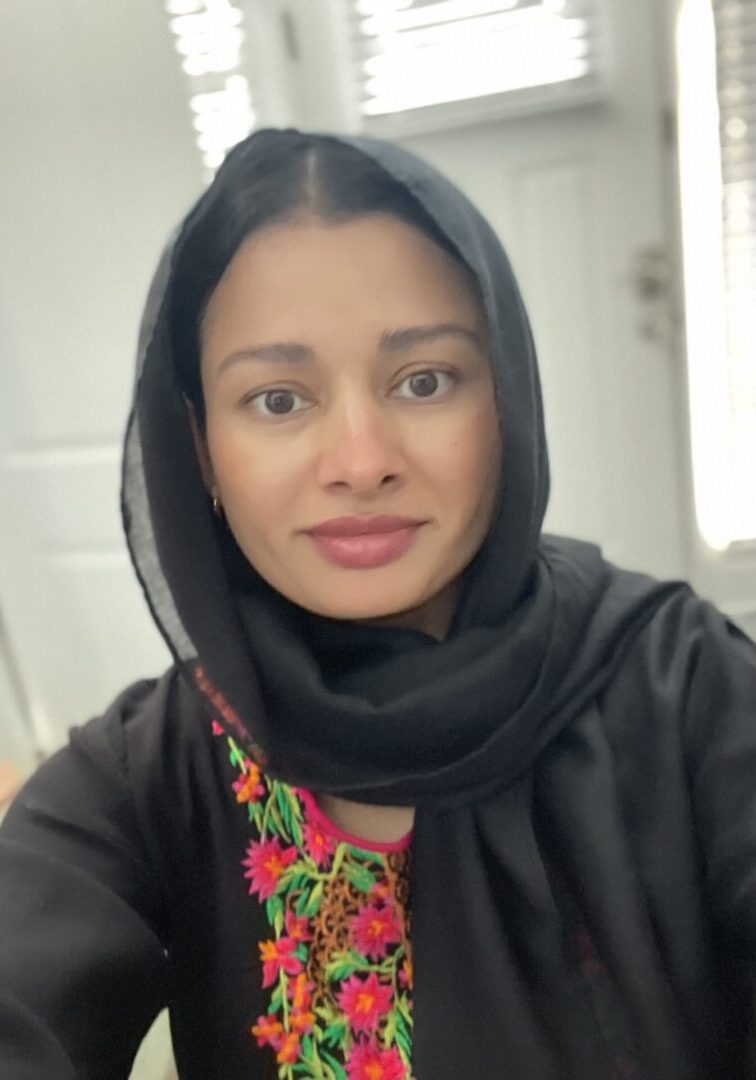 Woman wearing black hijab with colorful embroidery.