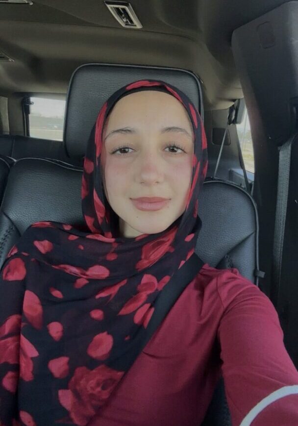 A Woman In A Red COlor Top And A Scarf