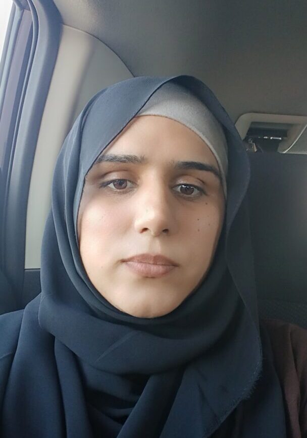 Woman wearing hijab in car seat.